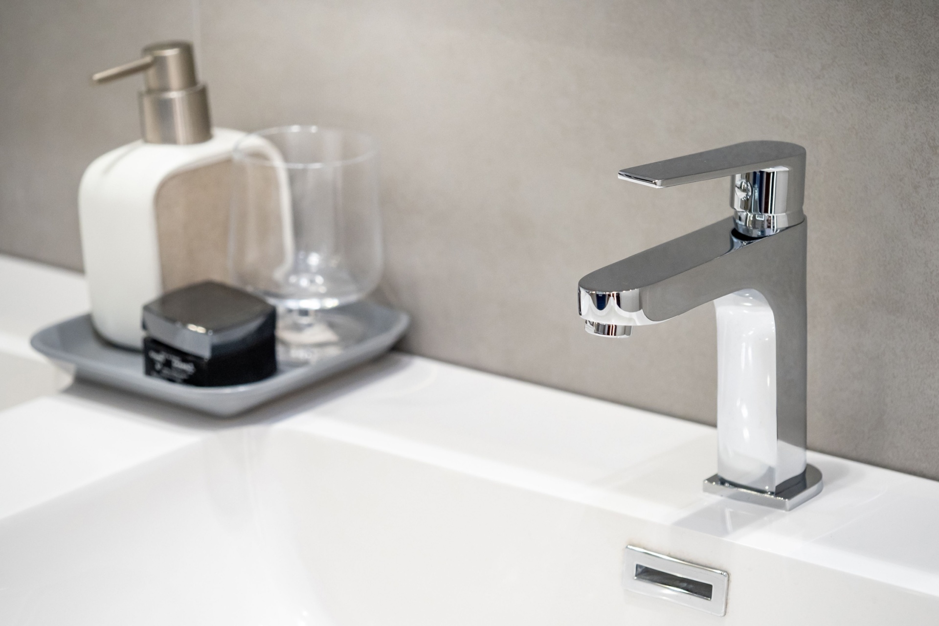Servant i sølv krom ved en hvit vask på et bad